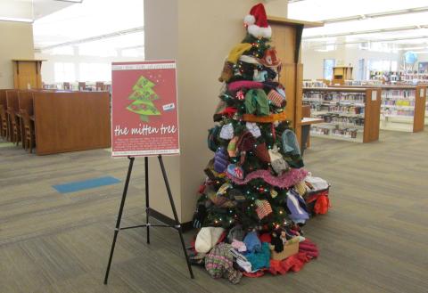 Winter tree decorated with hats, scarves, and mittens