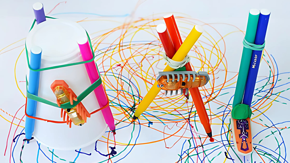 Little robot hexbugs connected to markers by rubber bands making colorful scribbles